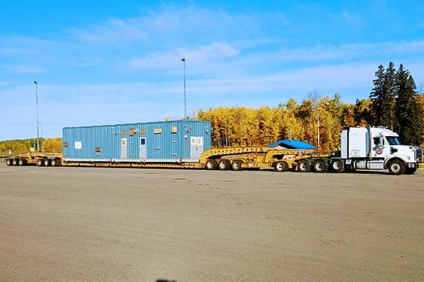 Modular site building on a multi-axle lowboy trailer